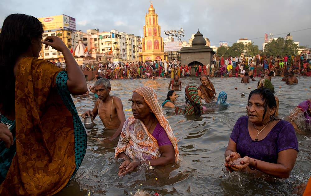 Devotees perform rituals as they take holy dips in the Godavari River during Kumbh Mela, or Pitcher Festival, in Nasik, India.