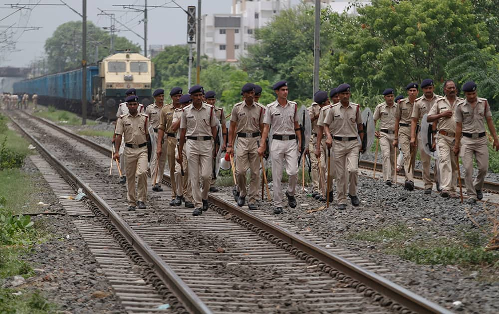 Railway police personnel patrol after a mob stopped trains and damaged tracks in Ahmedabad, India.