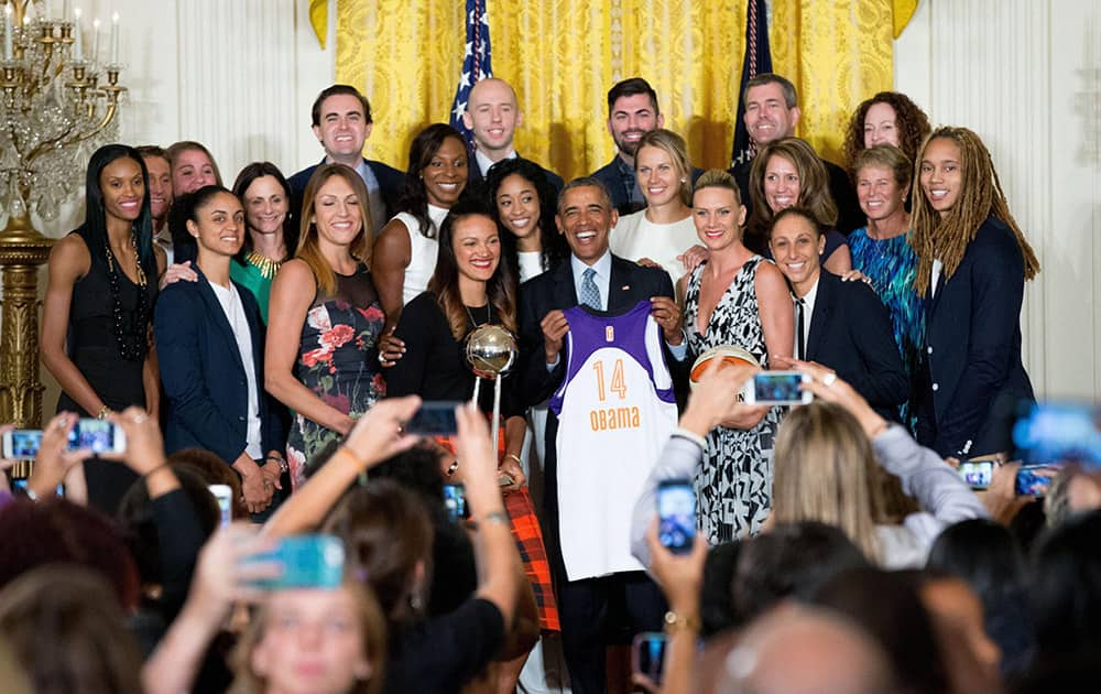 President Barack Obama poses with the Phoenix Mercury in the East Room of the White House in Washington.
