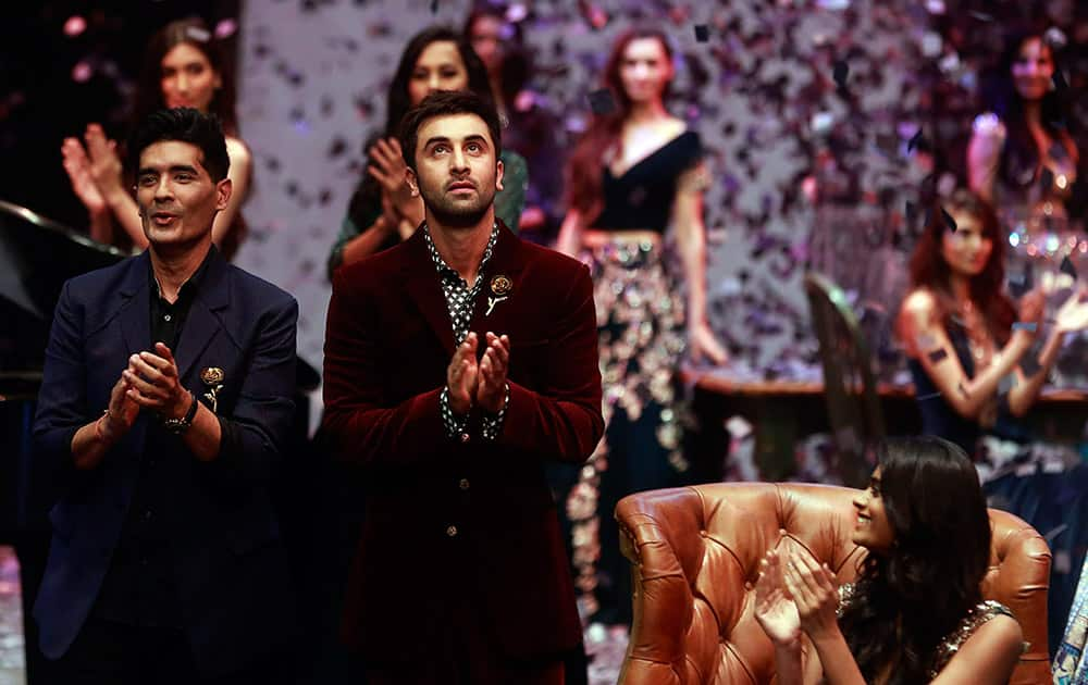 Designer Manish Malhotra, along with Bollywood actor Ranbir Kapoor clap at the end of Malhotra's fashion show, during Lakme Fashion Week in Mumbai.