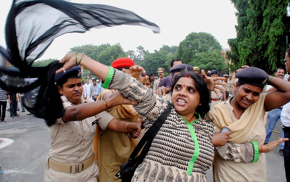 Police arrest a woman who was showing black flags to Delhi Chief Minister Arvind Kejriwal on his arrival at the airport in Patna.