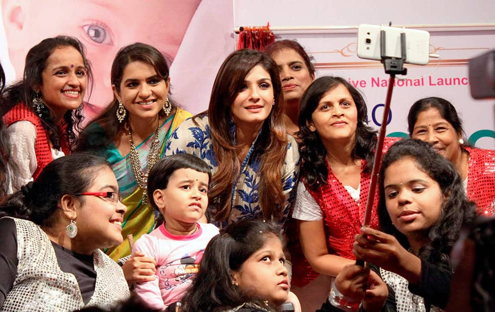 Ravina Tandon and BJP leader Shaina N C taking selfies with special children at the launch of Spina Bifida (Birth Defect) Awareness Campaign in Mumbai.