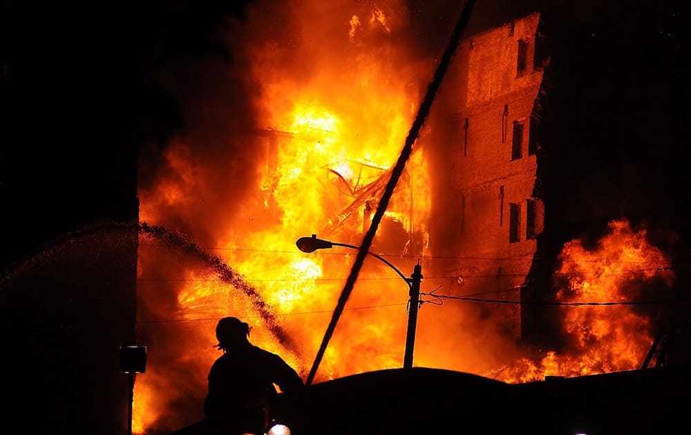 A firefighter battles a fire at the Sandone Tire warehouse in Scranton, Pa. Officials said the warehouse houses an estimated 20,000 tires.