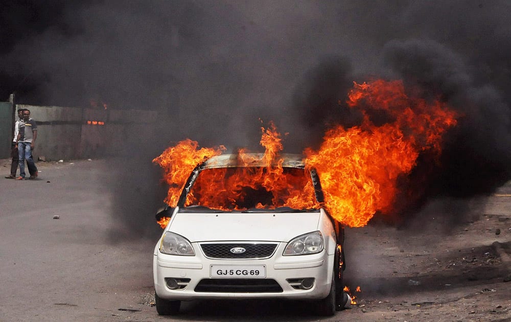 A car that was set on fire Patidar community agitating for resarvation in Surat.