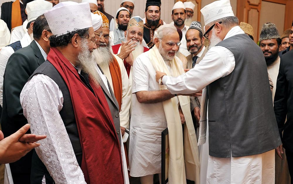 Prime Minister Narendra Modi is presented a scarf as he meets with a delegation of Sufi Scholars at PM House in New Delhi.