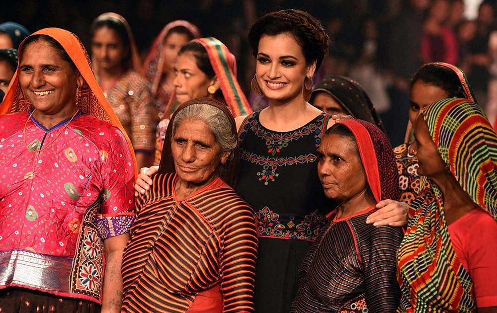 Dia Mirza along with weavers displays a creation of designer Anita Dongre during the Lakme Fashion Week.