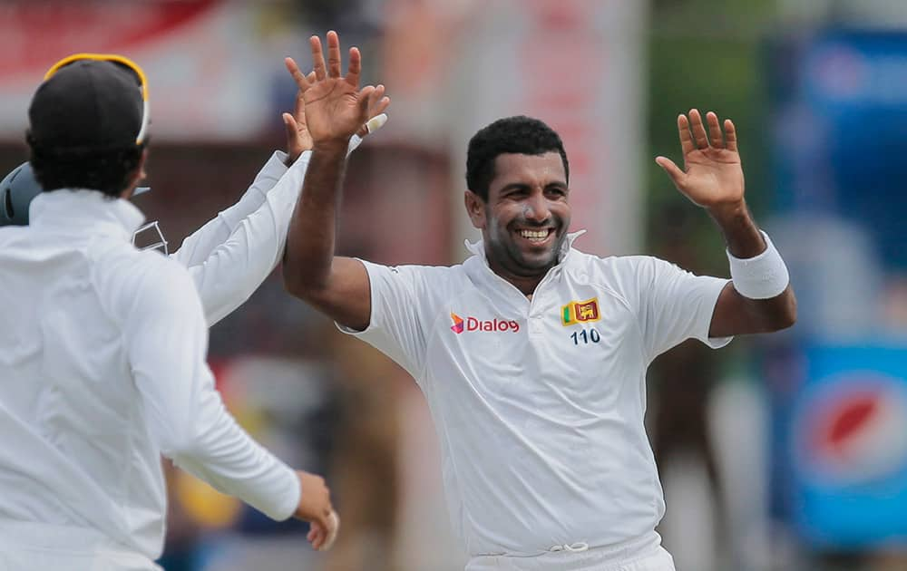 Sri Lanka's Dhammika Prasad celebrates the dismissal of India's Lokesh Rahul with his team mates on the day one of the third test cricket match in Colombo, Sri Lanka.