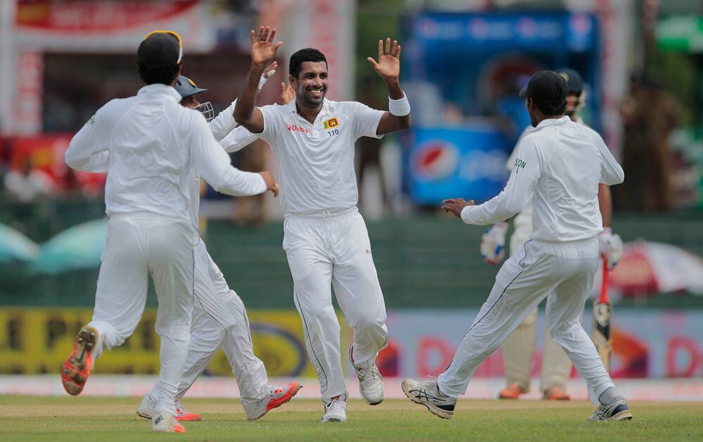 Sri Lanka's Dhammika Prasad celebrates the dismissal of India's Lokesh Rahul with his team mates on the day one of the third test cricket match in Colombo, Sri Lanka.