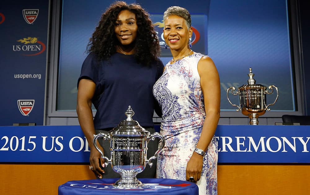 Defending US Open Tennis women's singles champion Serena Williams of the United States, poses with USTA president Katrina Adams and the women's singles trophy following a news conference and the US Open draw ceremony at the USTA Billie Jean King National Tennis Center in New York.