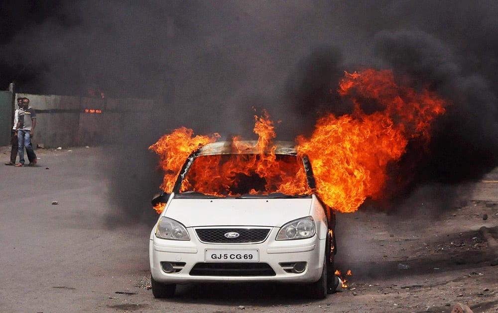 A car that was set on fire Patidar community agitating for resarvation in Surat.