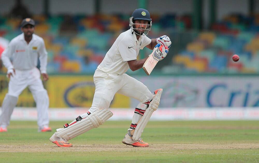 Cheteshwar Pujara plays a shot against Sri Lanka on the day one of their third test cricket match in Colombo, Sri Lanka.