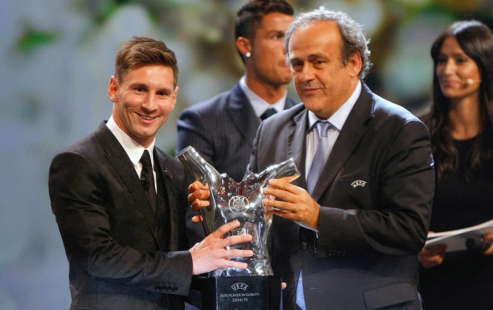 UEFA Prez Michel Platini (R) gives the trophy for best player of the year to Barcelonas Lionel Messi of Argentina, during the UEFA Champions League draw at the Grimaldi Forum.