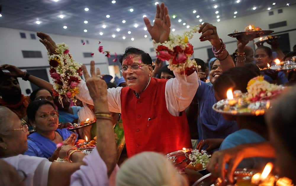 Widows and scavenger women, earlier considered “untouchables,” surround Bindeshwar Pathak, founder of non-governmental organization Sulabh International, as they tie 