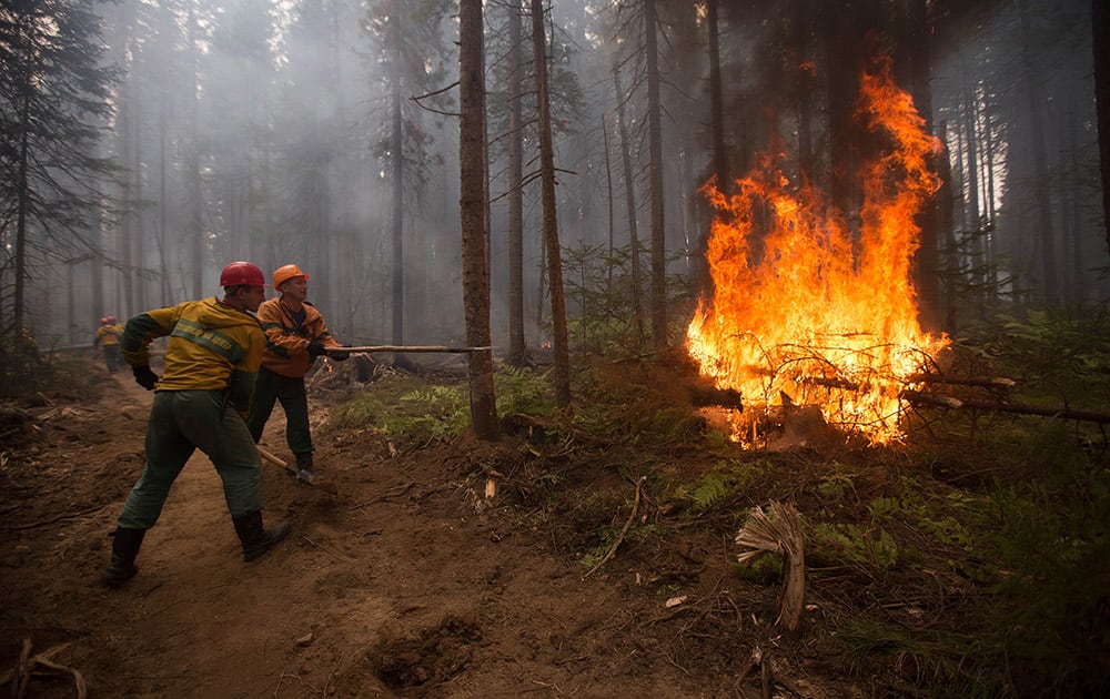 Firefighters extinguish flames from a wildfire near Turka in Siberia, Russia. There are reports of spreading forest fires in Siberia