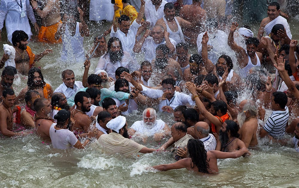 Sadhus, or Hindu holy men, surround their guru, center, during a bath in the Godavari River during Kumbh Mela, or Pitcher Festival in Nashik.