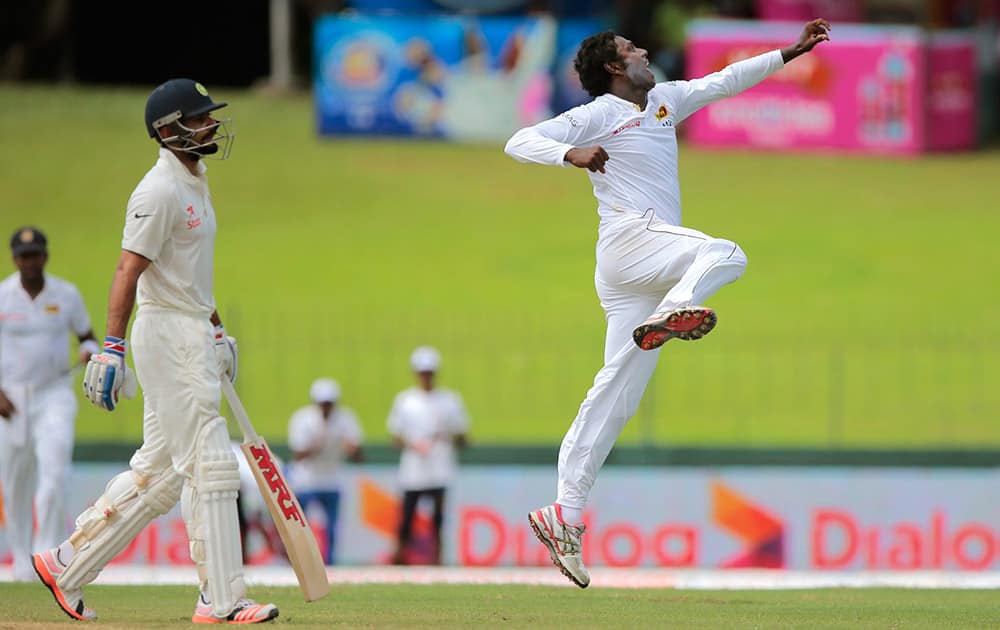 Sri Lanka's Angelo Mathews, right, celebrates the dismissal of India's Virat Kohli, left, on the day two of their second test cricket match in Colombo.