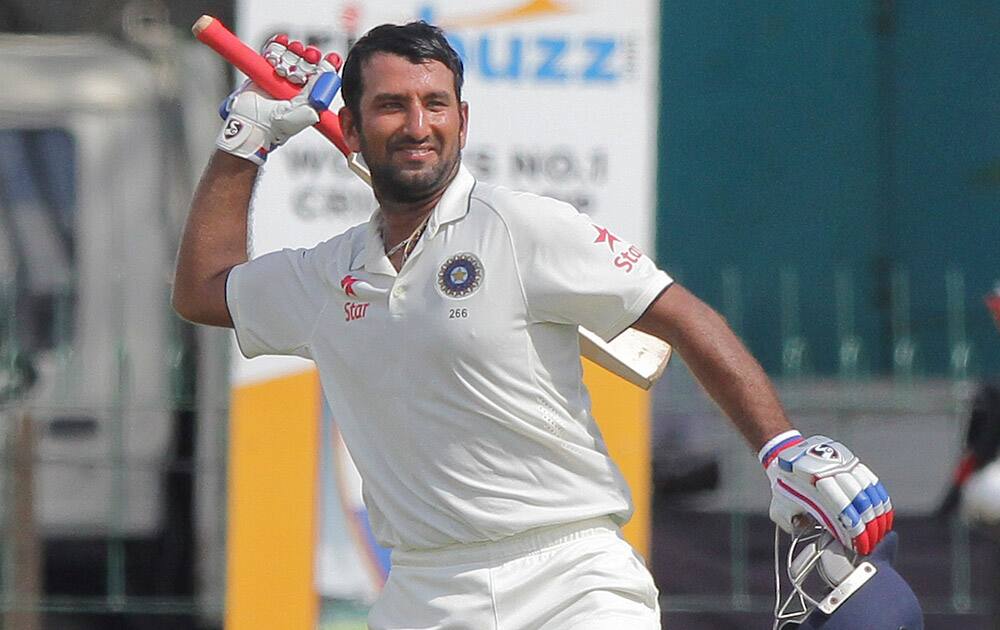 Cheteshwar Pujara, celebrates scoring hundred runs on the second day of their third test cricket match against Sri Lanka in Colombo.