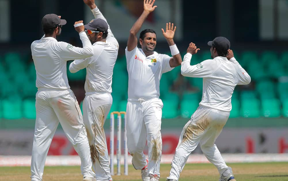 Dhammika Prasad, second right, celebrates the dismissal of India's Ravichandran Ashwin on the second day of their third test cricket match in Colombo.