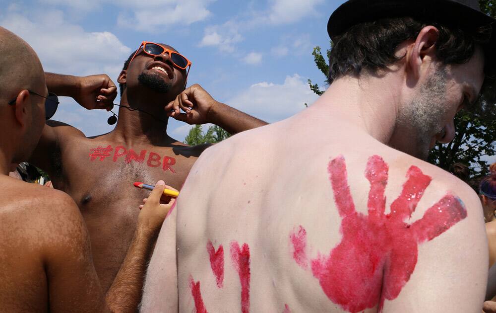 Participants in the Philly Naked Bike Ride paint each other before riding in Philadelphia.