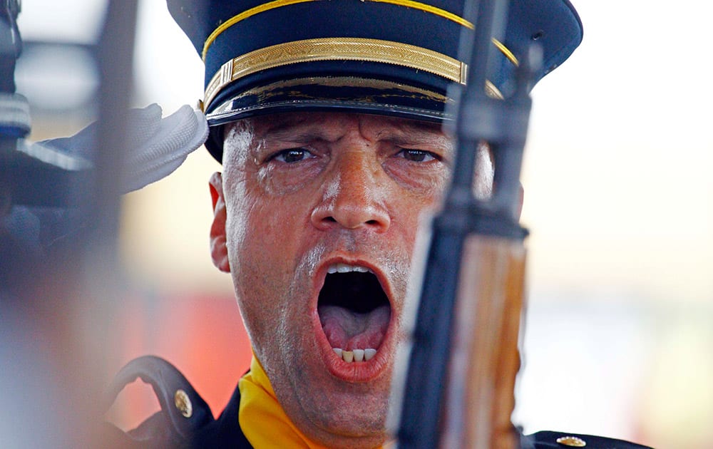 A joint Gulfport Fire Department honor guard leader shouts out orders to post the colors during the Katrina 10 Year Remembrance event in Gulfport, Miss.