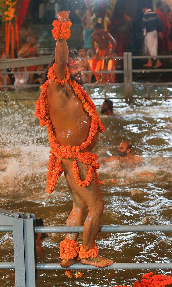 A Naga sadhu, or naked Hindu holy shouts religious slogans before taking a holy dip in the Godavari River during Kumbh Mela, or Pitcher Festival, at Trimbakeshwar in Nasik, India.