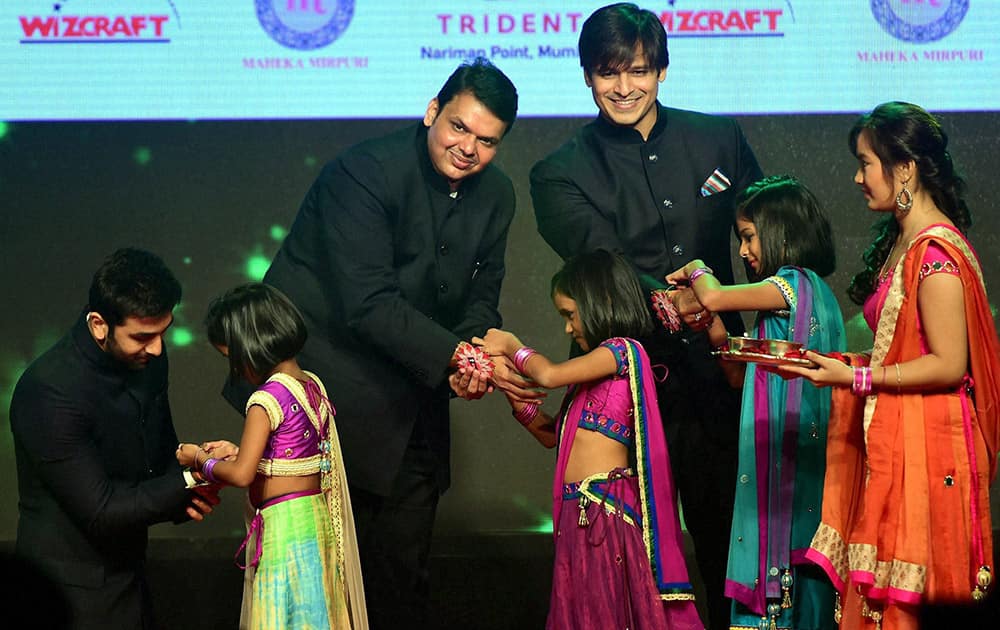 Girls tie Rakhi to actor Ranbeer Kapoor, Maharashta Chief Minister, Devendra Fadnavis and actor Vivek Oberoi during a event to spread awareness against human trafficking in Mumbai.