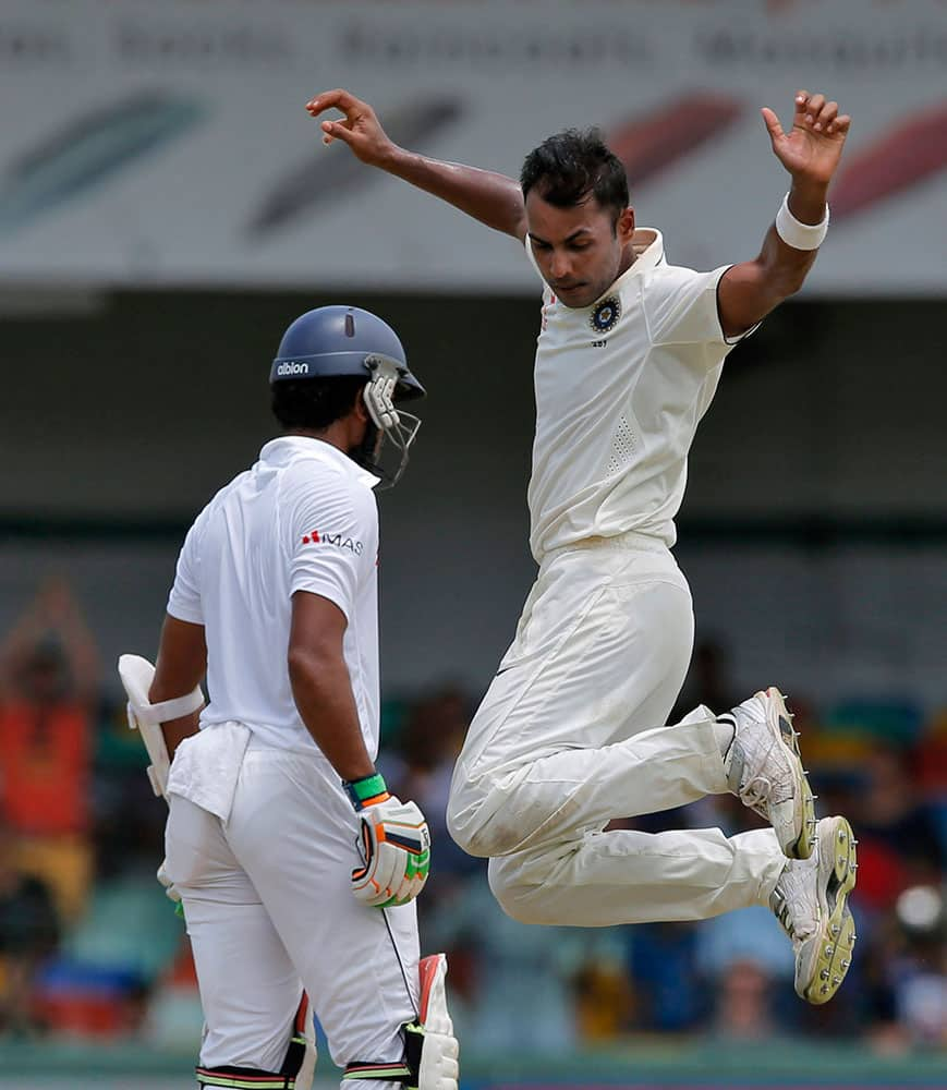 India's Stuart Binny, right, celebrates the dismissal of Sri Lanka's Dinesh Chandimal on the third day of their third test cricket match between them in Colombo, Sri Lanka.