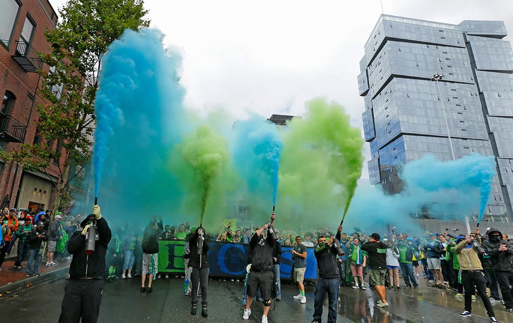 Members of the Emerald City Supporters set off smoke effects during the traditional March to the Match before an MLS soccer match between the Seattle Sounders and the Portland Timbers in Seattle.