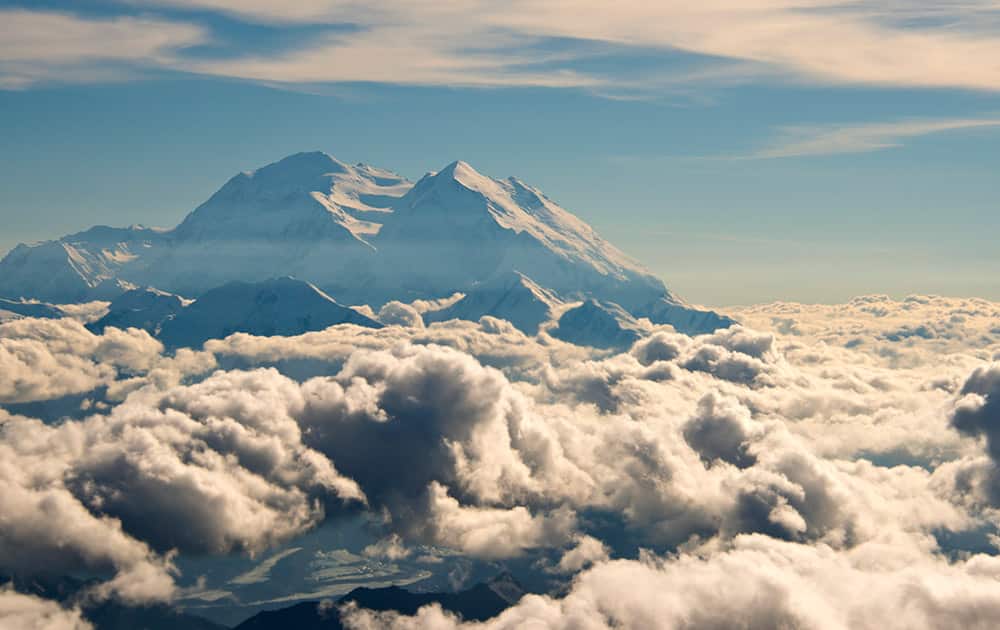 aerial photo provided by Holland America Line, Mount McKinley pierces through the clouds above Denali National Park and Preserve in Alaska.