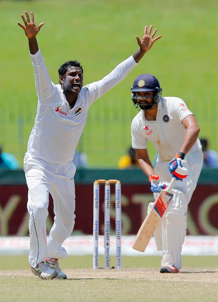 Sri Lanka's Angelo Mathews, left, unsuccessfully appeals to dismiss India's Rohit Sharma on the day four of the third cricket test match in Colombo, Sri Lanka.