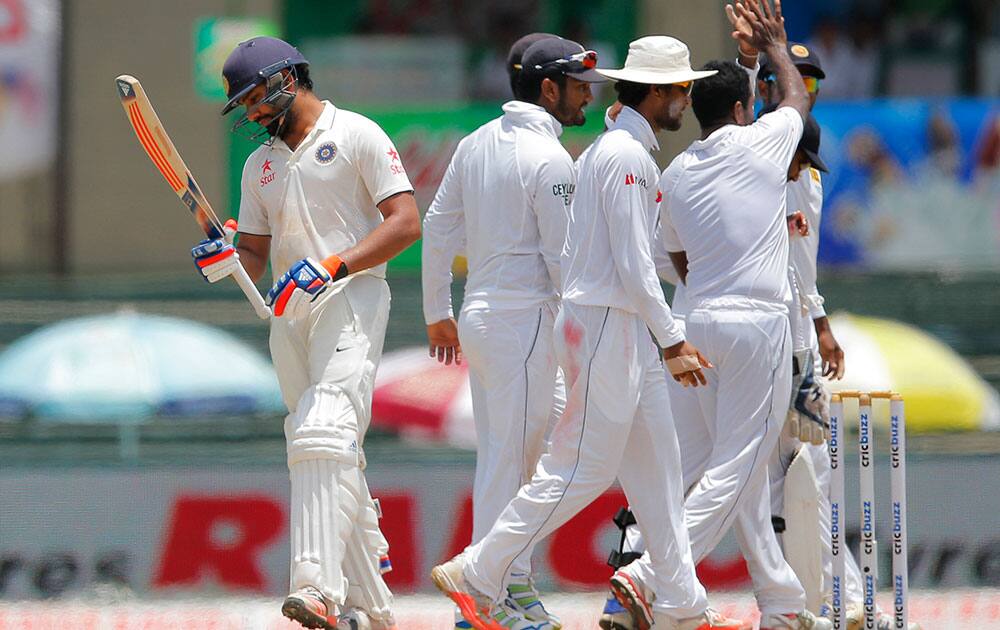 India's Rohit Sharma, left, leaves after being dismissed as Sri lankan players celebrate on the day four of their third test cricket mat in Colombo, Sri Lanka.