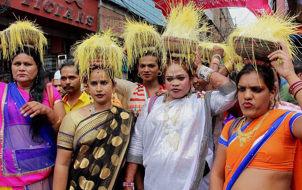 Eunuchs carry wheat saplings on their heads during a procession taken out to celebrate Bhujaria festival in Bhopal.