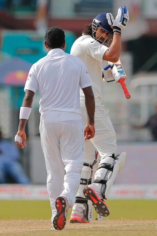 Sri Lankan bowler Dhammika Prasad, back to camera and India's Ishant Sharma exchange words on day four of the third test cricket match between them in Colombo, Sri Lanka.