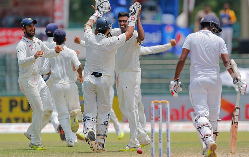 Ravichandran Ashwin face to camera celebrates the wicket of Sri Lanka's Lahiru Thirimanne with team mates on the final day of their third test cricket match in Colombo, Sri Lanka.