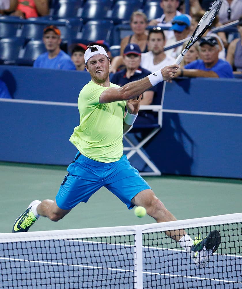 Illya Marchenko, of Ukraine, returns a shot to Gael Monfils, of France, during the first round of the US Open Tennis tournament in New York.