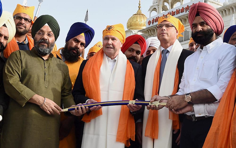 DSGMC President Manjit Singh G.K and General Secretary Manjinder Singh Sirsa presenting a sword to Australian Defence Minister Kevin Andrews during his visit to Gurudwara Bangla Sahib in New Delhi.