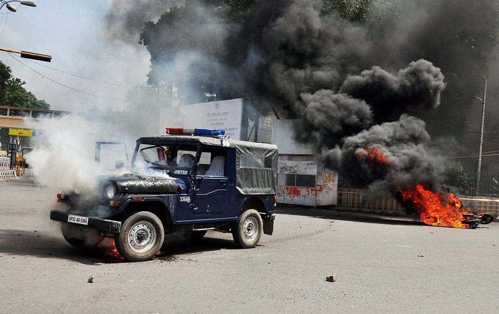 B P Ed Sangharsh Morcha members set afire vehicles during their protest for jobs in front of Vidhan Sabha in Lucknow.