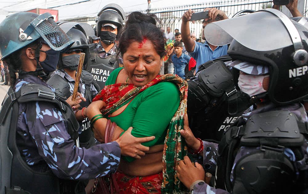 Nepalese policewomen try to stop a Hindu activist as they block a road and try to enter a restricted area near the Nepalese Constituent Assembly Hall during a protest in Kathmandu, Nepal.