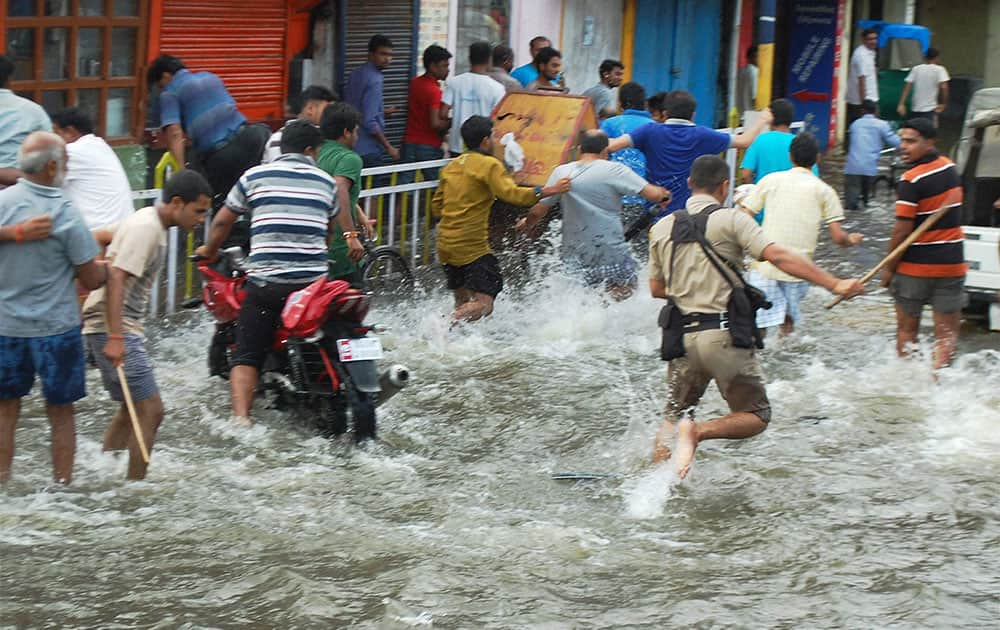 Police lathicharge the mob who were holding a protest seeking relief from water logging, in flooded Dibrugarh town in Assam.