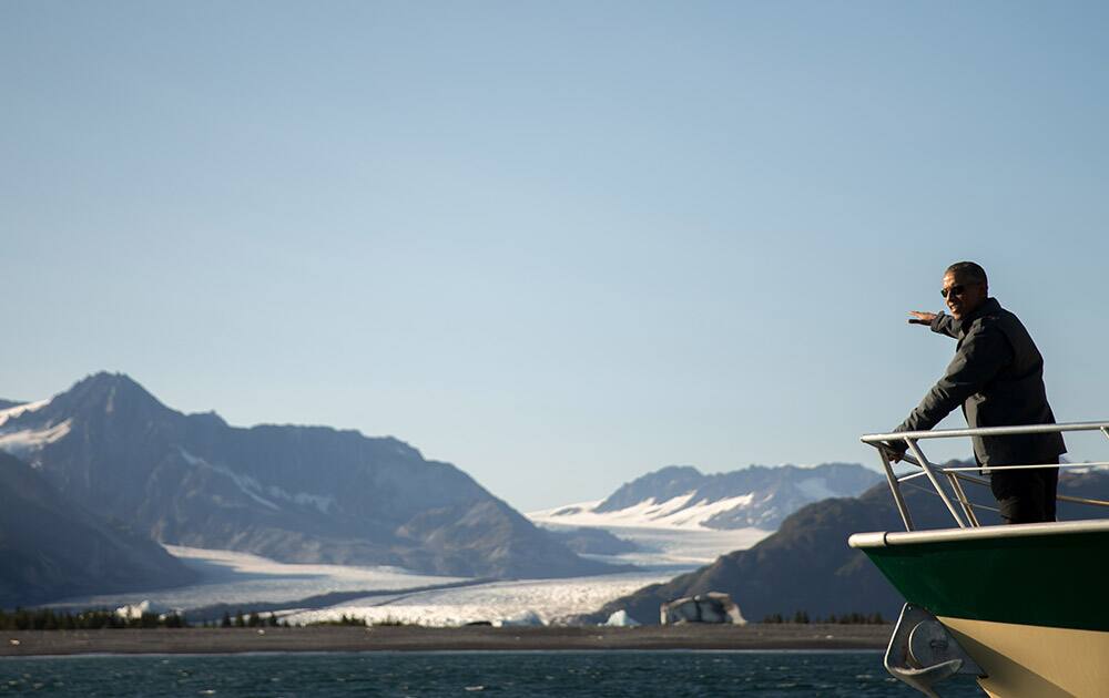 President Barack Obama looks at Bear Glacier, which has receded 1.8 miles in approximately 100 years, while on a boat tour to see the effects of global warming in Resurrection Cove, in Seward, Alaska.