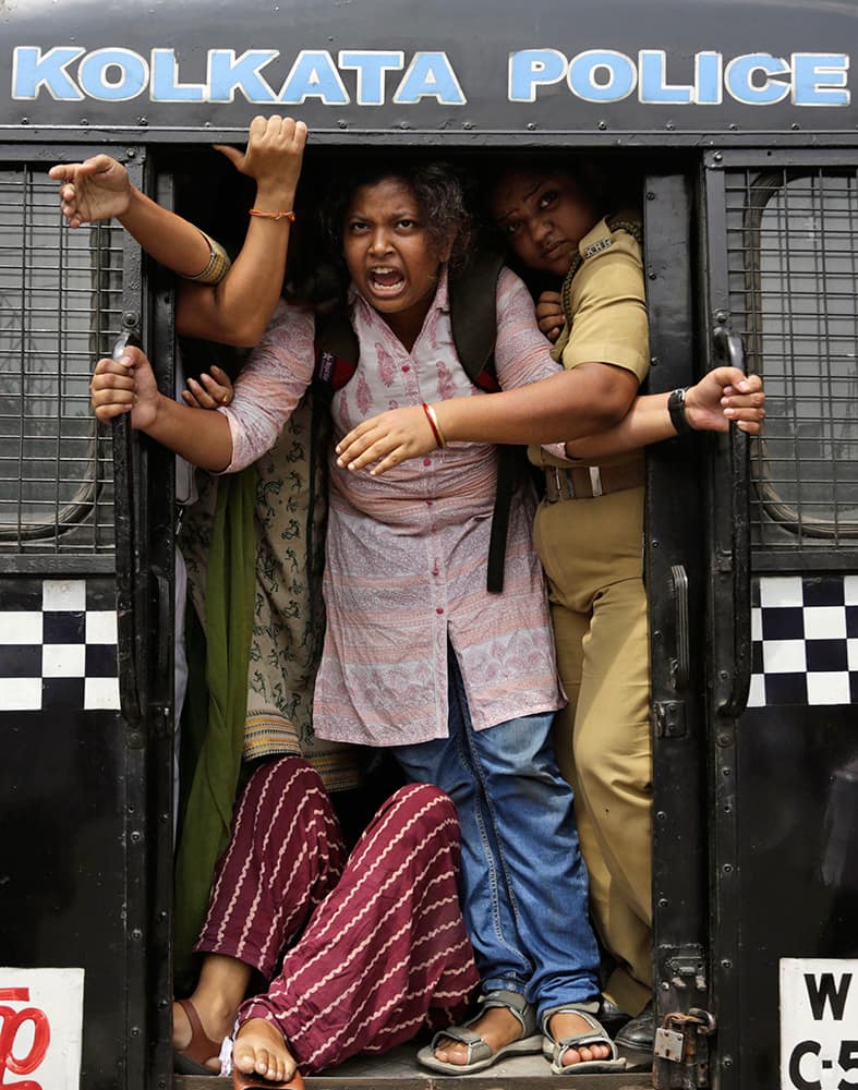 An activist of Socialist Unity Center of India shouts slogans as she is detained by the police in a van during a daylong nationwide strike called by the trade unions in Kolkata, India.