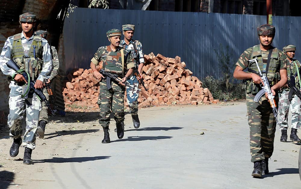 Army personnel move towards the house where militants were holed up at Ladoora village in Rafiabad area of Baramulla district.