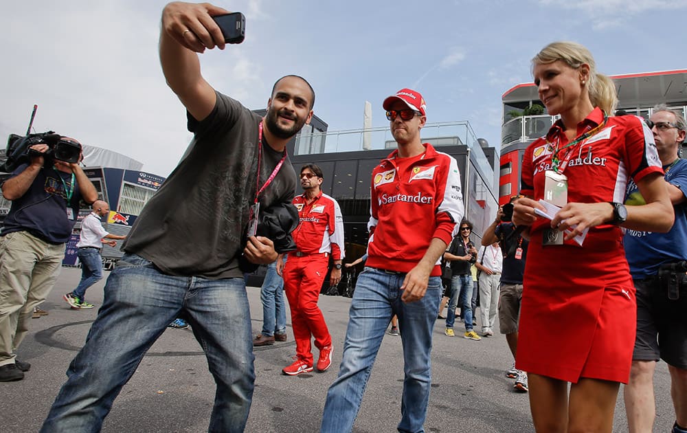 Ferrari driver Sebastian Vettel of Germany walks in the paddock at the Monza racetrack, in Monza, Italy.