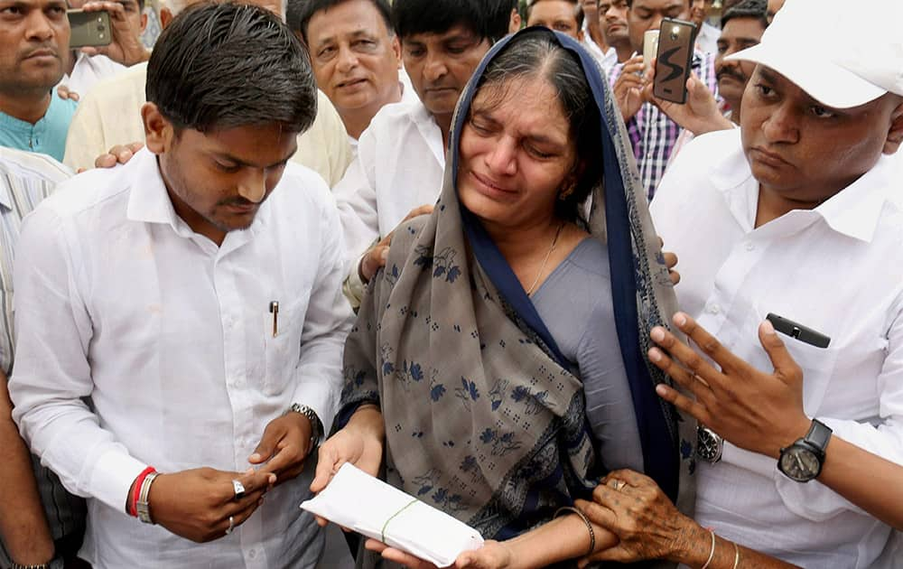 Prabhaben Patel, mother of Shwetang Patel, weeps as Convener of Patidar Anamat Andolan Samiti Hardik Patel consoles her during prayer meeting of her son in Ahmedabad.