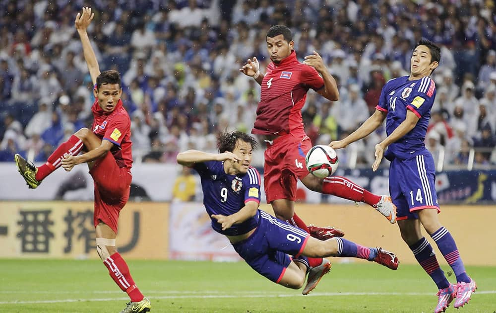 Japans Shinjji Okazaki (9), second left, and Yoshinori Muto, right, battle for the ball with Cambodias Thierry Chatha Bin (4) and Rous Samoeun, left, in front of the Cambodias goal during their second round soccer match of regional qualifiers for the 2018 World Cup in Saitama, north of Tokyo.