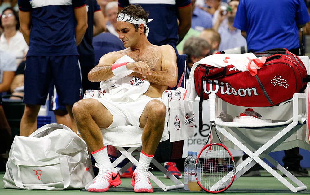 Roger Federer, of Switzerland, towels off between sets against Steve Darcis, of Belgium, during the second round of the U.S. Open tennis tournament in New York. Federer won 6-1, 6-2, 6-1.