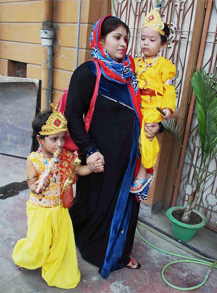 A Muslim woman with her children dressed up as Lord Krishna during a celebration program on the eve of Krishna Janmashtami festival in Allahabad.