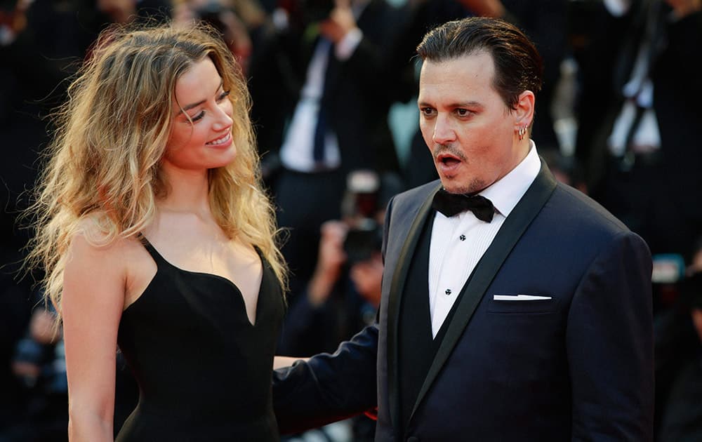 Amber Heard and Johnny Depp pose for photographers upon arrival at the premiere of the film Black Mass during the 72nd edition of the Venice Film Festival in Venice, Italy.