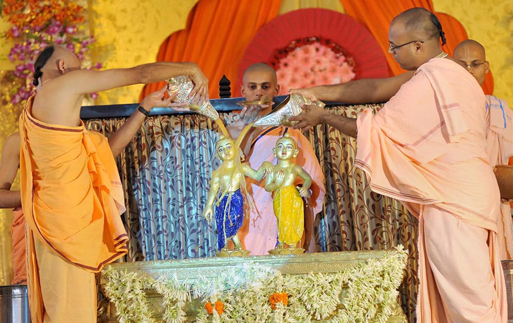 A priest performs abhishek of Lord Krishna at Krishna Balaram temple in Akshaya Patra on the occasion of Janmashtami in Jaipur.