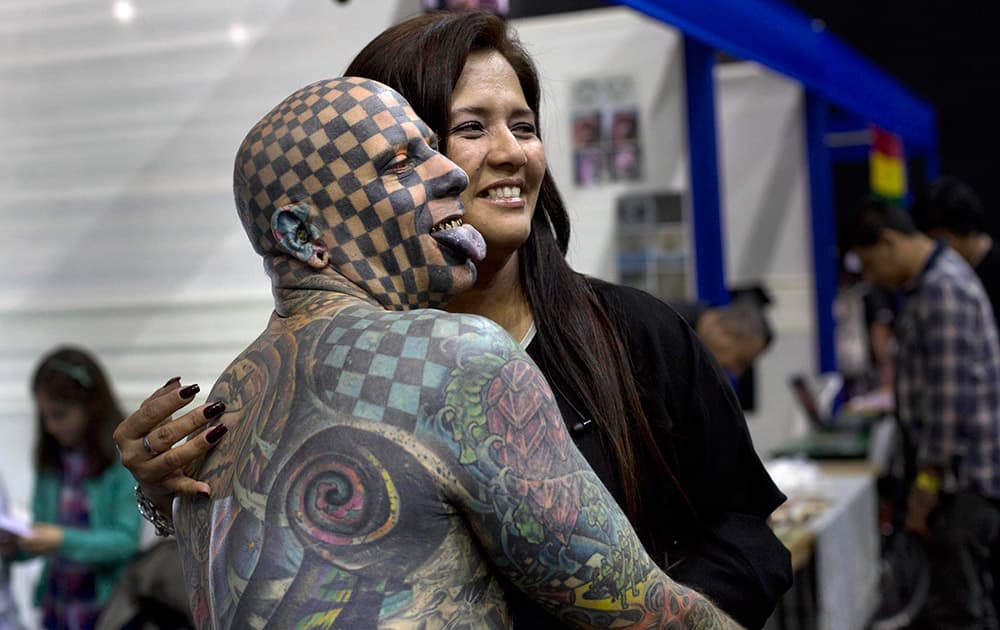 Matt Gone from the U.S. poses for photos with a fan during a tattoo festival in Lima, Peru.